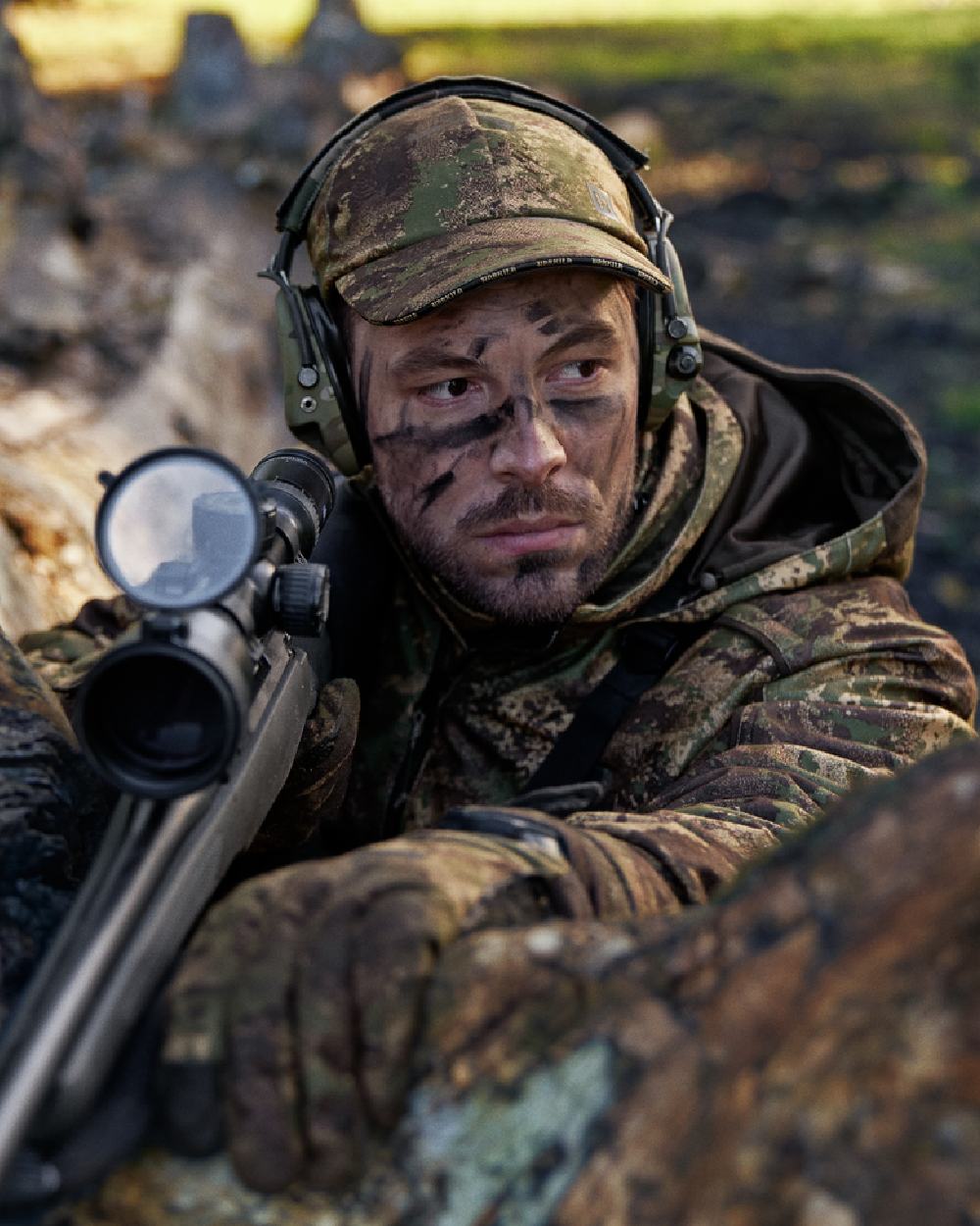 AXIS Forest Coloured Harkila Deer Stalker Camo HWS Cap on blurry background #colour_axis-forest