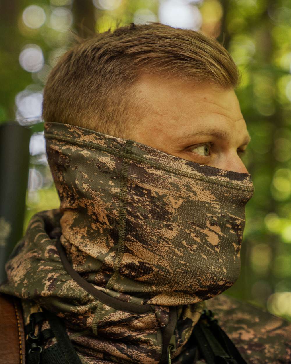 AXIS Forest Coloured Harkila Deer Stalker Camo Neck Gaiter on blurry background #colour_axis-forest