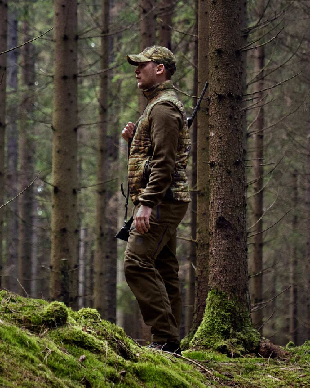 Willow Green AXIS Forest Coloured Harkila Deer Stalker Camo Reversible Packable Waistcoat on forest background #colour_willow-green-axis-forest