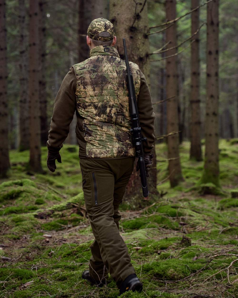 Willow Green AXIS Forest Coloured Harkila Deer Stalker Camo Reversible Packable Waistcoat on forest background #colour_willow-green-axis-forest