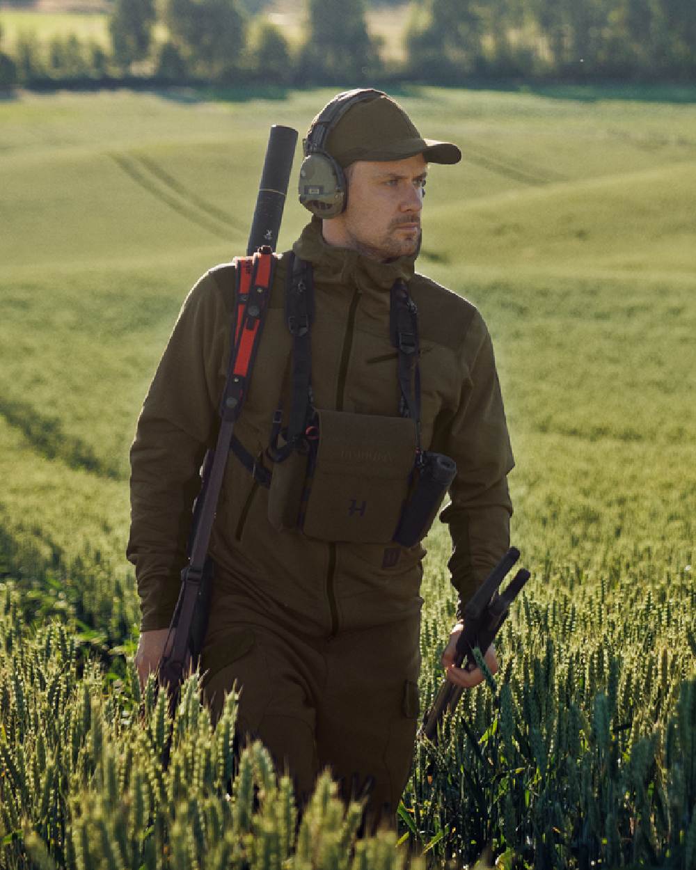 Willow Green Shadow Brown Coloured Harkila Deer Stalker Fleece Hoodie on outdoor background #colour_willow-green-shadow-brown