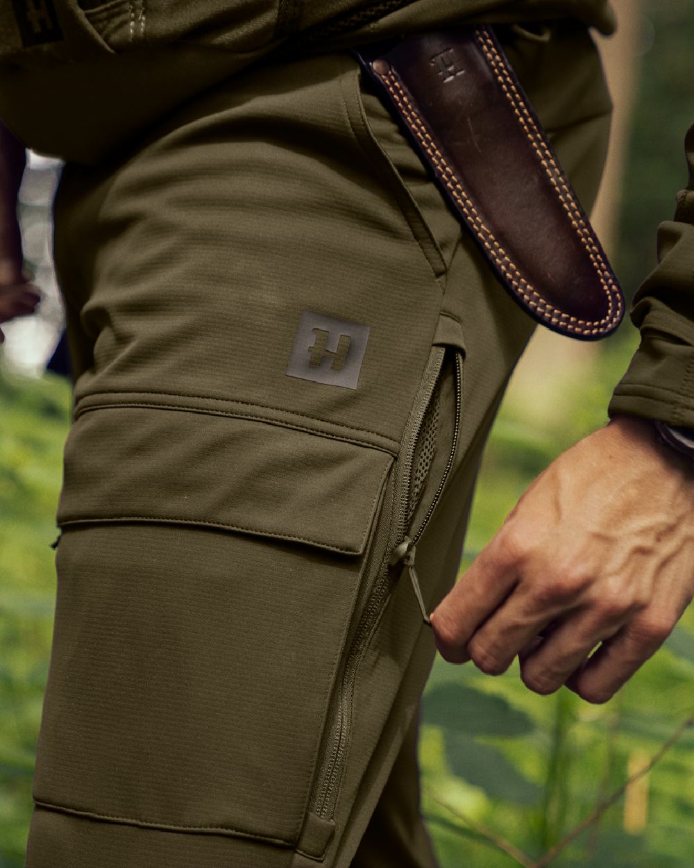 Willow Green Shadow Brown Coloured Harkila Deer Stalker Light Trousers on outdoor background #colour_willow-green-shadow-brown