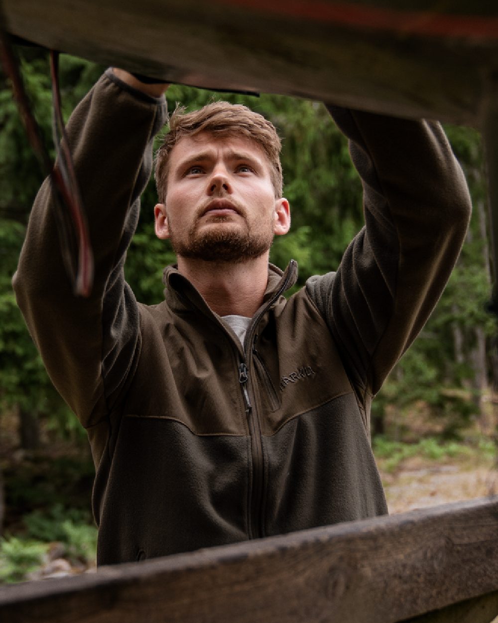 Shadow Brown Coloured Harkila Fjell Fleece Jacket on forest background #colour_shadow-brown