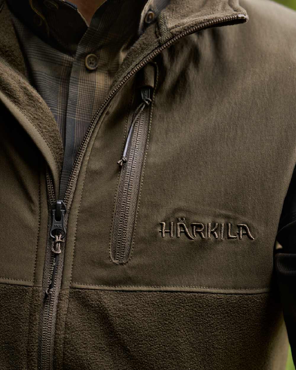 Hunting Green Willow Green Coloured Harkila Fjell Fleece Waistcoat on blurry background #colour_hunting-green-willow-green