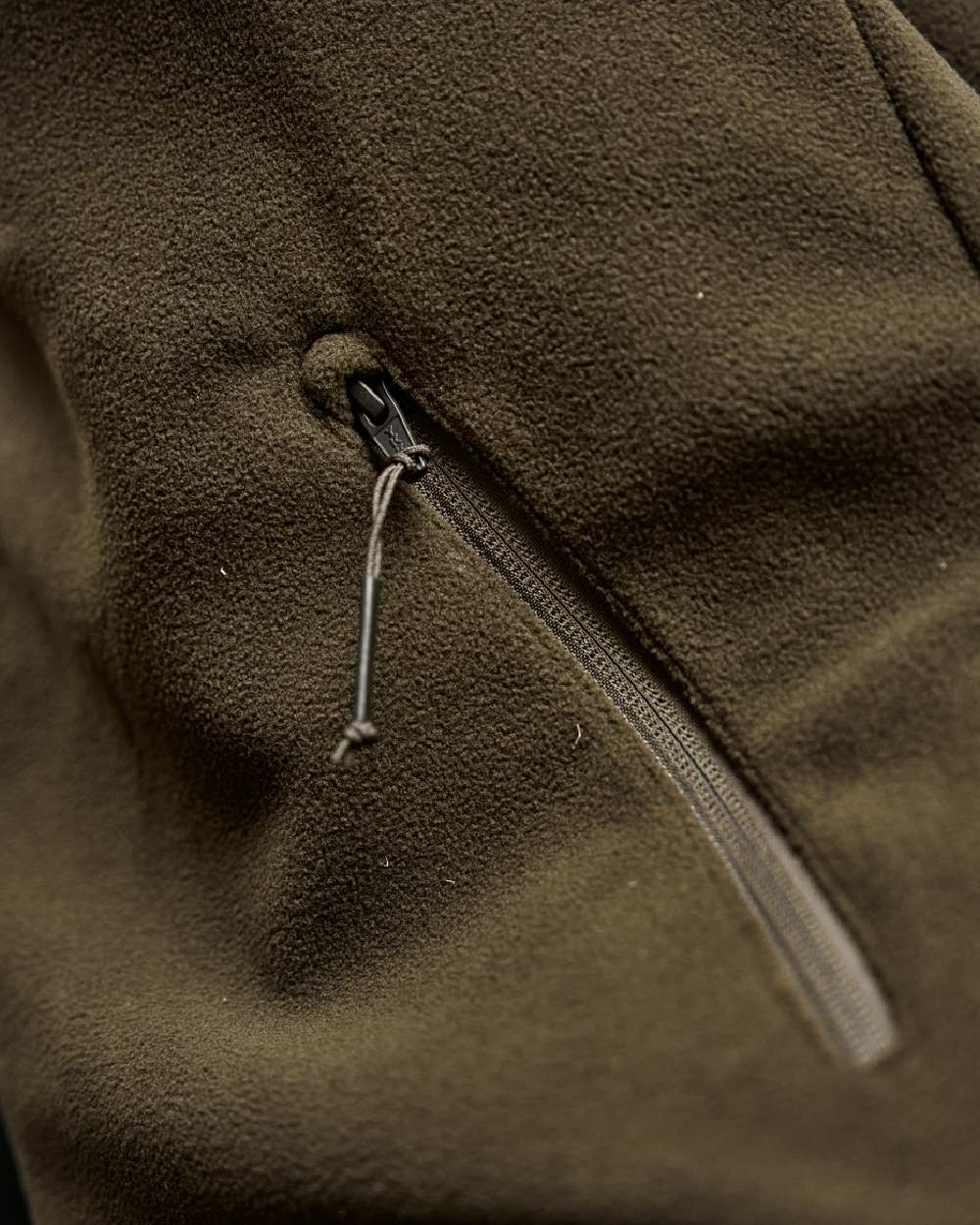 Hunting Green Willow Green Coloured Harkila Fjell Fleece Waistcoat on blurry background #colour_hunting-green-willow-green