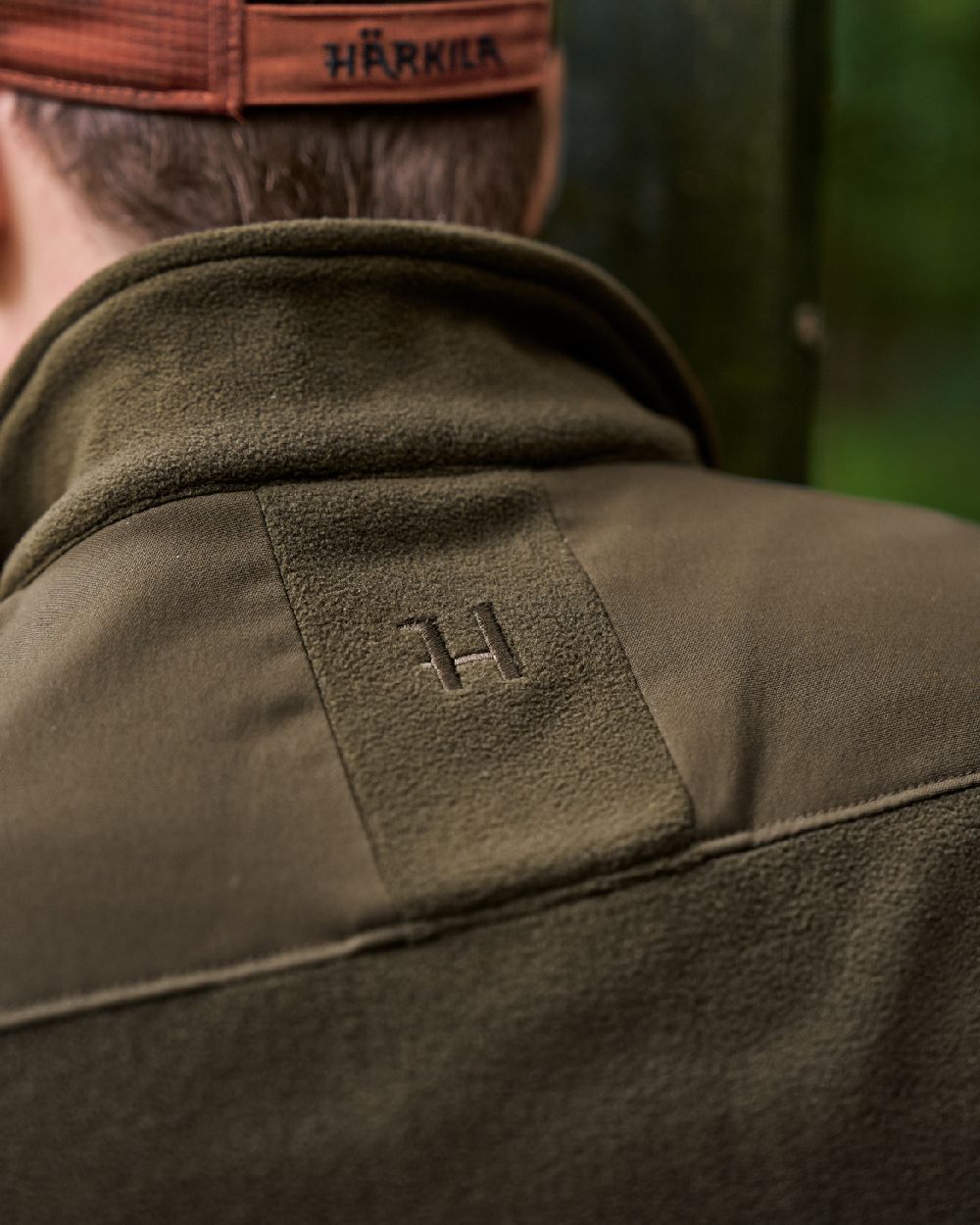 Hunting Green Willow Green Coloured Harkila Fjell Fleece Waistcoat on blurry background #colour_hunting-green-willow-green
