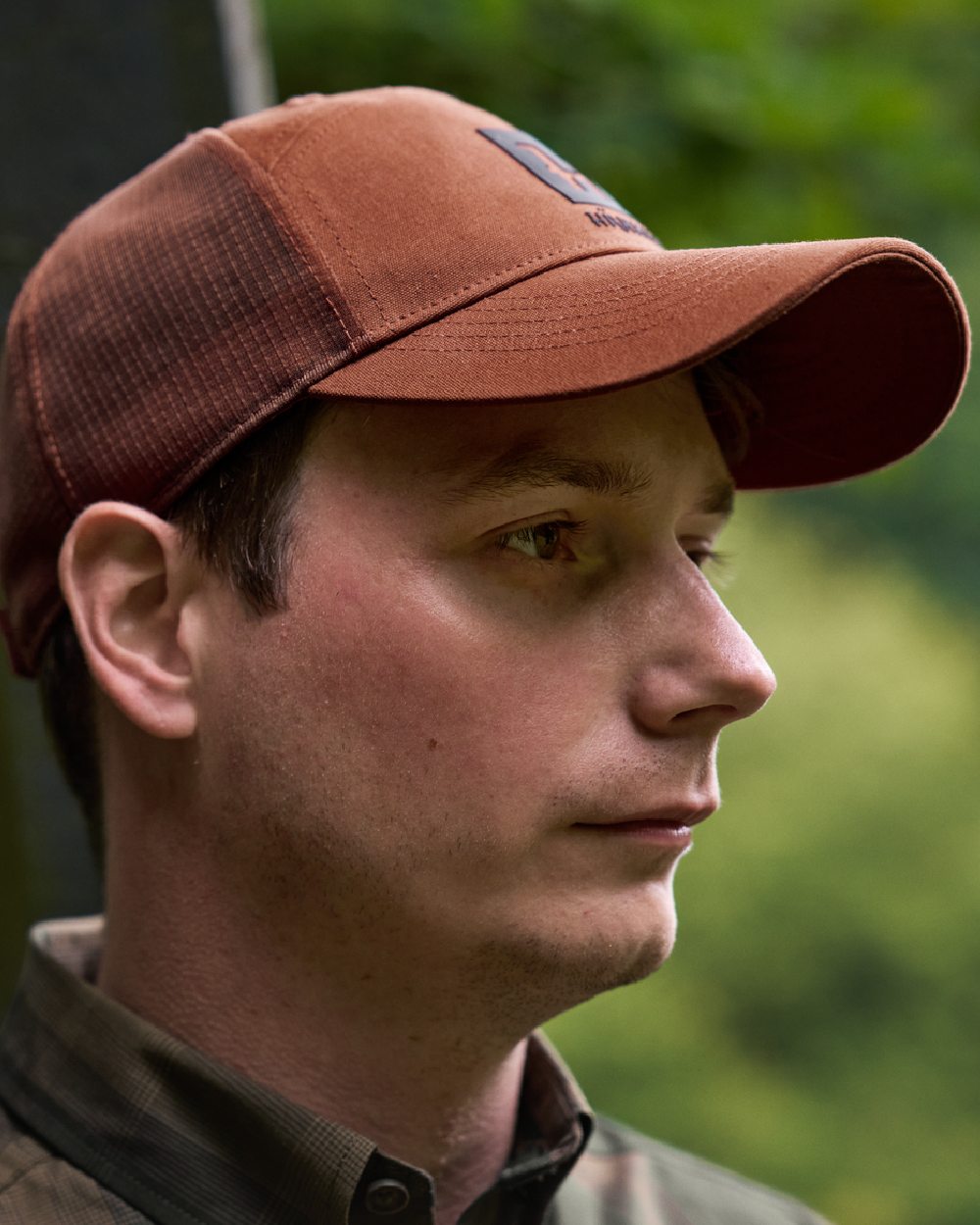 Arabian Spice Coloured Harkila Instinct Cap on blurry background #colour_arabian-spice