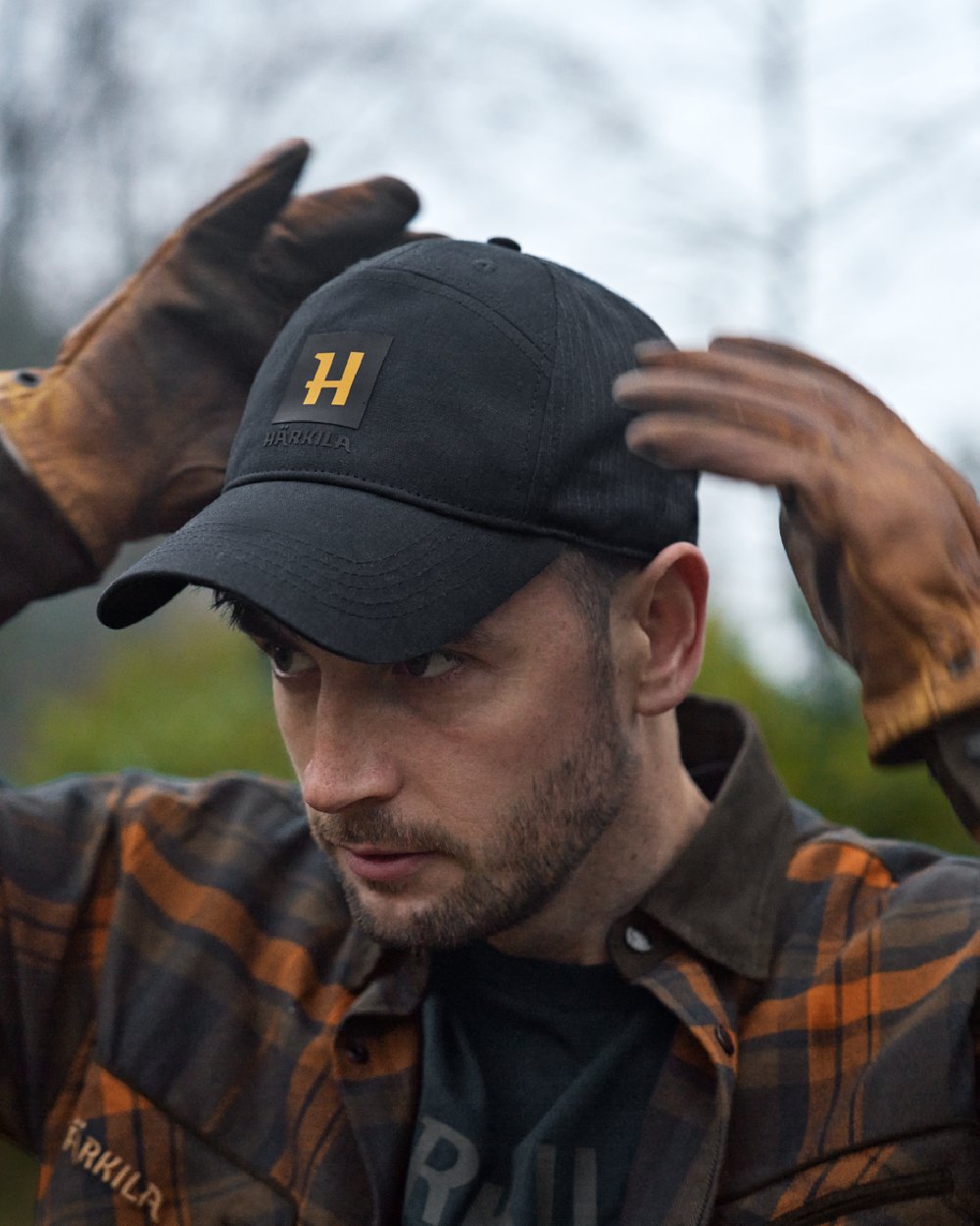 Dark Navy Coloured Harkila Instinct Cap on blurry background #colour_dark-navy