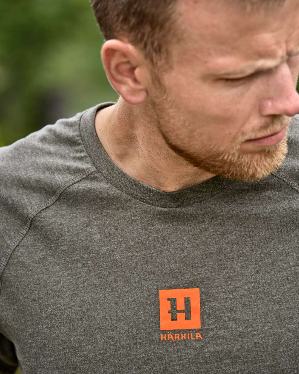 Green Melange coloured Harkila Instinct Short Sleeve T-Shirt on forest background #colour_green-melange