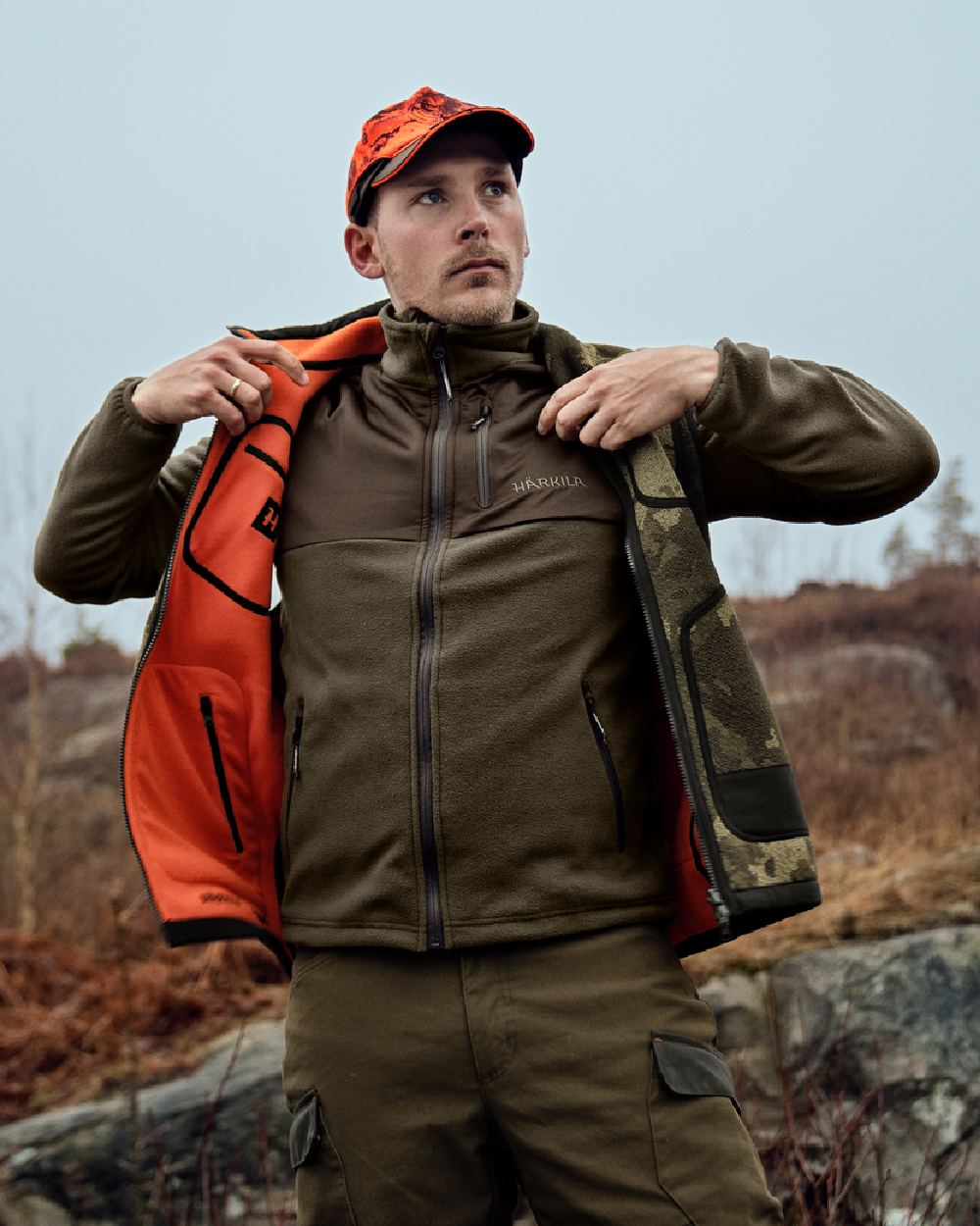 AXIS Limited Edition Orange Coloured Harkila Kamko Pro Edition Reversible Hi-Vis Waistcoat on forest background #colour_axis-limited-edition-orange