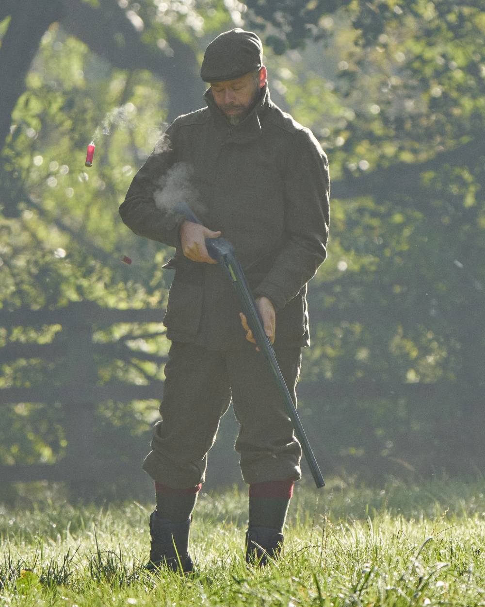 Forest Green Herringbone Coloured Harkila Kenmore GTX Jacket on forest background #colour_forest-green-herringbone