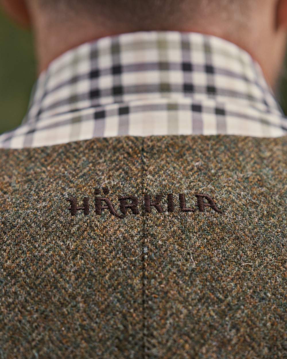 Forest Green Herringbone coloured Harkila Kenmore Shooting Waistcoat on forest background #colour_forest-green-herringbone