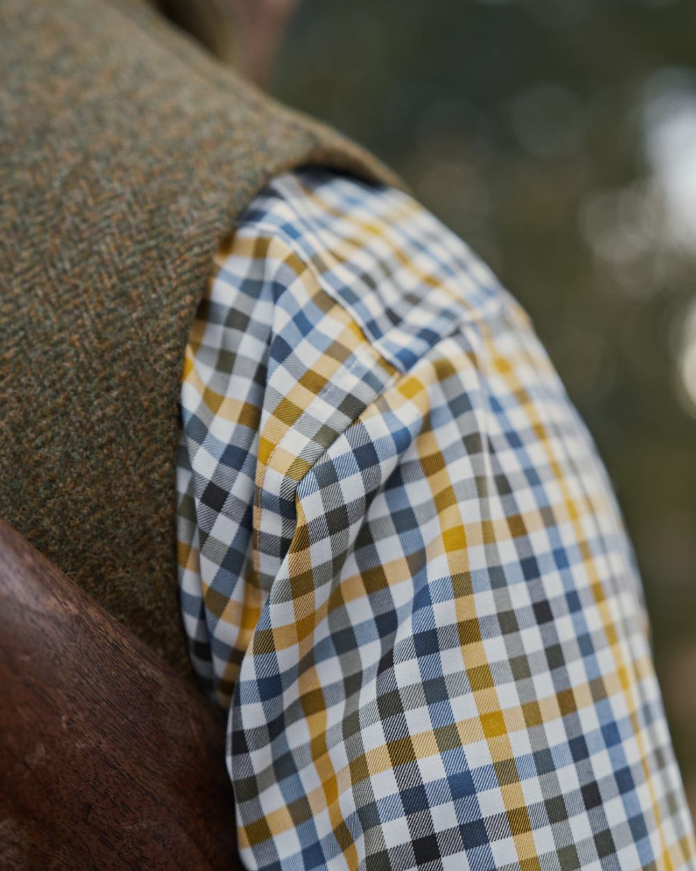 Forest Green Herringbone Coloured Harkila Kenmore Waistcoat on forest background #colour_forest-green-herringbone