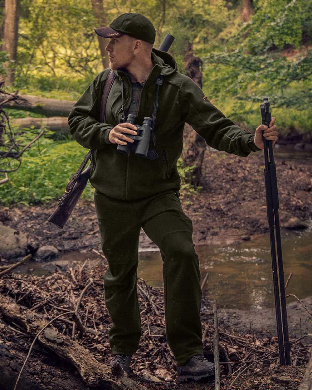 Willow Green Coloured Harkila Metso Hybrid Jacket on forest background #colour_willow-green