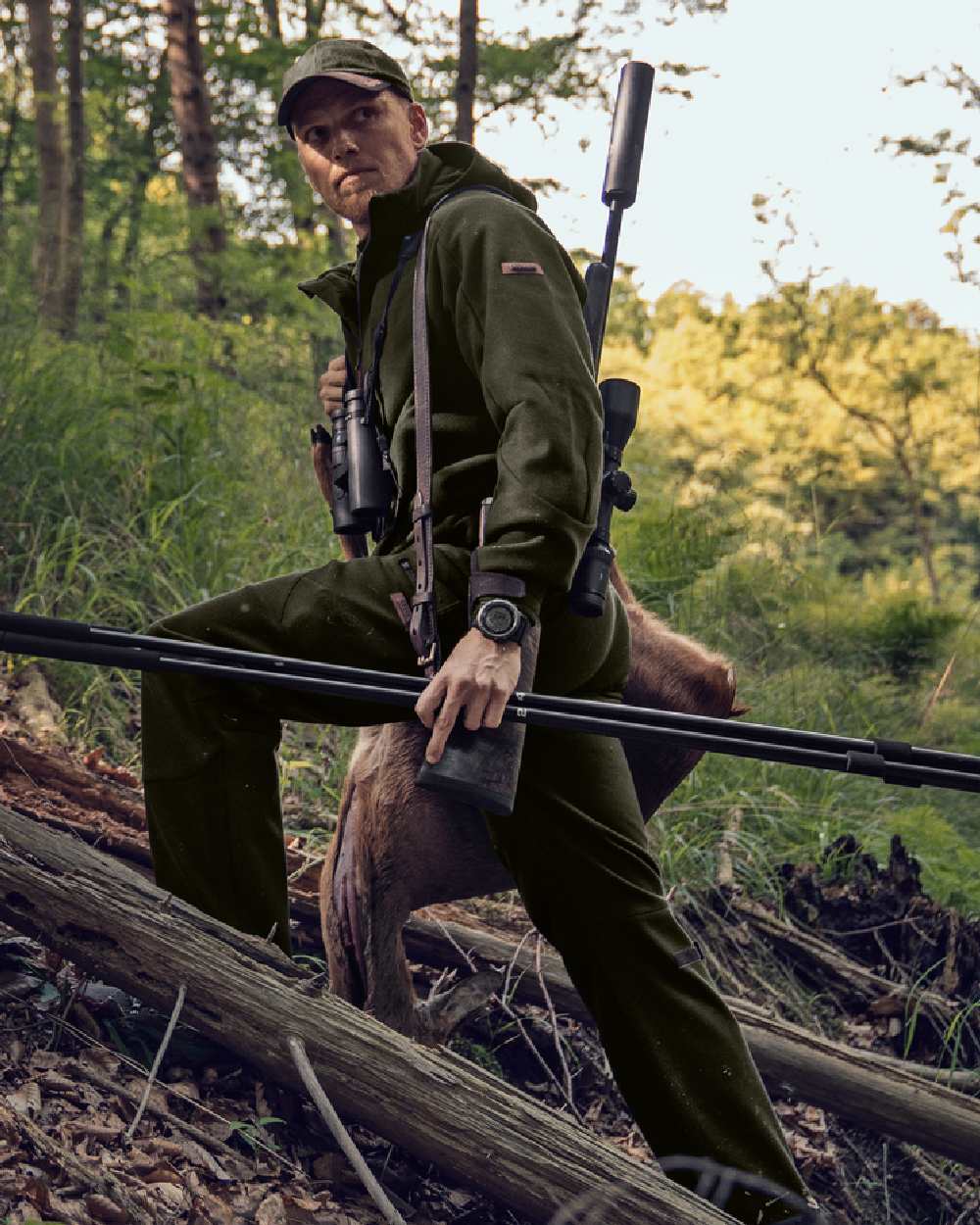 Willow Green Coloured Harkila Metso Hybrid Jacket on forest background #colour_willow-green