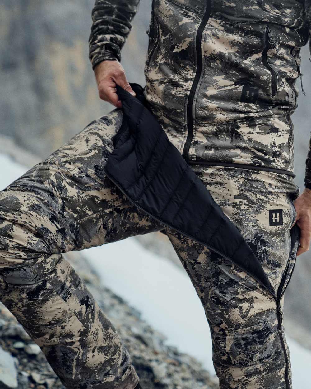 AXIS Mountain Coloured Harkila Mountain Hunter Expedition Packable Down Trousers on snow background #colour_axis-mountain