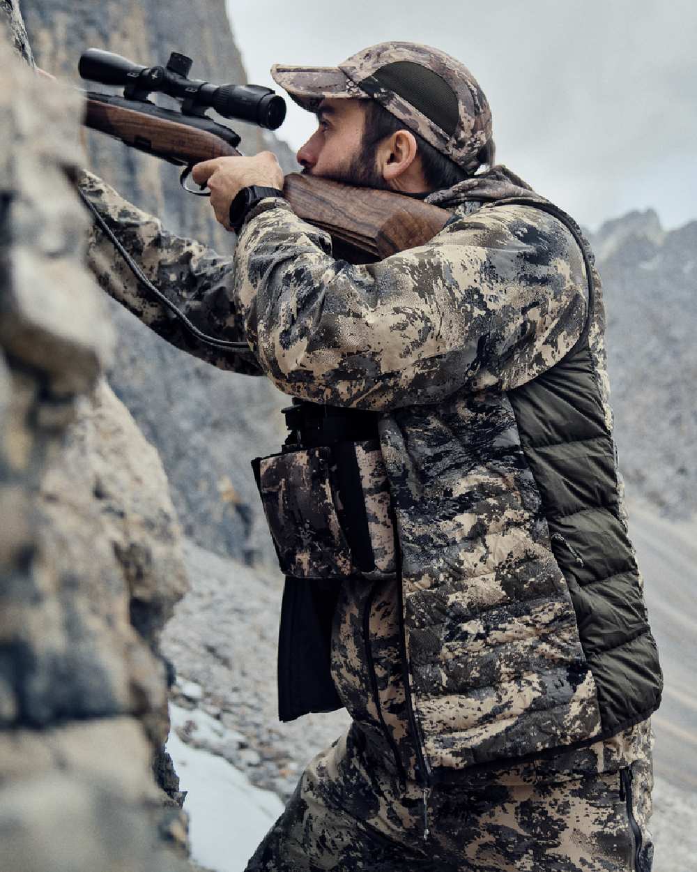 AXIS Mountain Shadow Brown Coloured Harkila Mountain Hunter Expedition Reversible Down Waistcoat on mountain background #colour_axis-mountain-shadow-brown