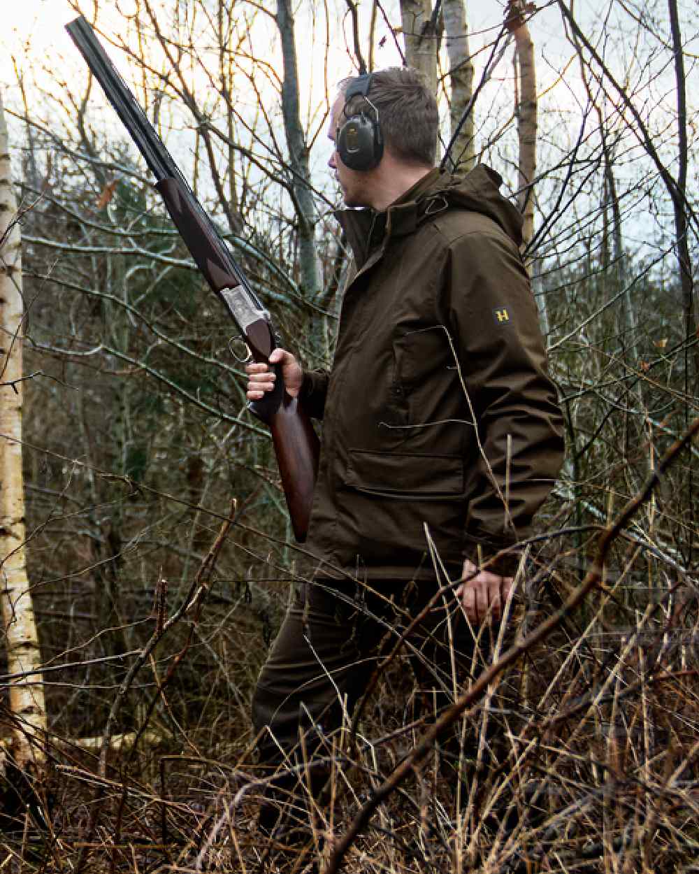 Willow Green Coloured Harkila Nordic Hunter HWS Jacket on outdoor background #colour_willow-green