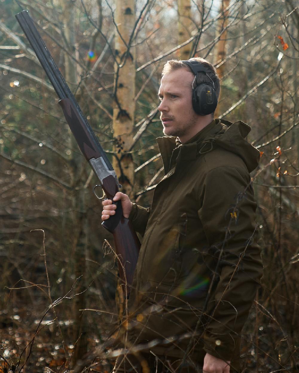 Willow Green Coloured Harkila Nordic Hunter HWS Jacket on outdoor background #colour_willow-green
