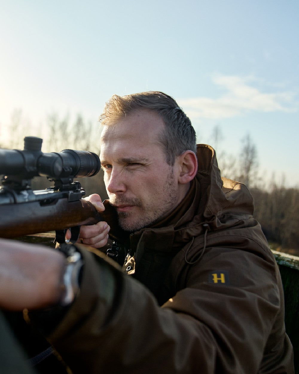 Willow Green Coloured Harkila Nordic Hunter HWS Jacket on outdoor background #colour_willow-green