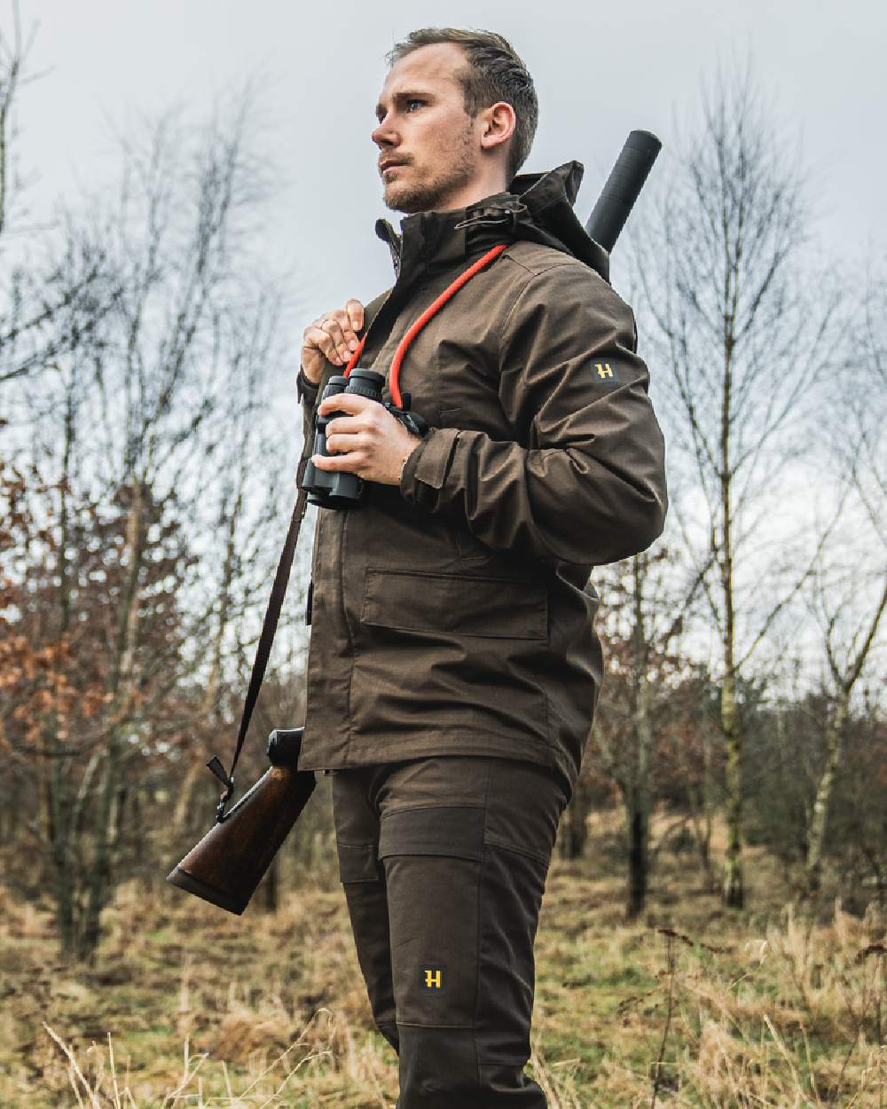 Willow Green Coloured Harkila Nordic Hunter HWS Jacket on outdoor background #colour_willow-green