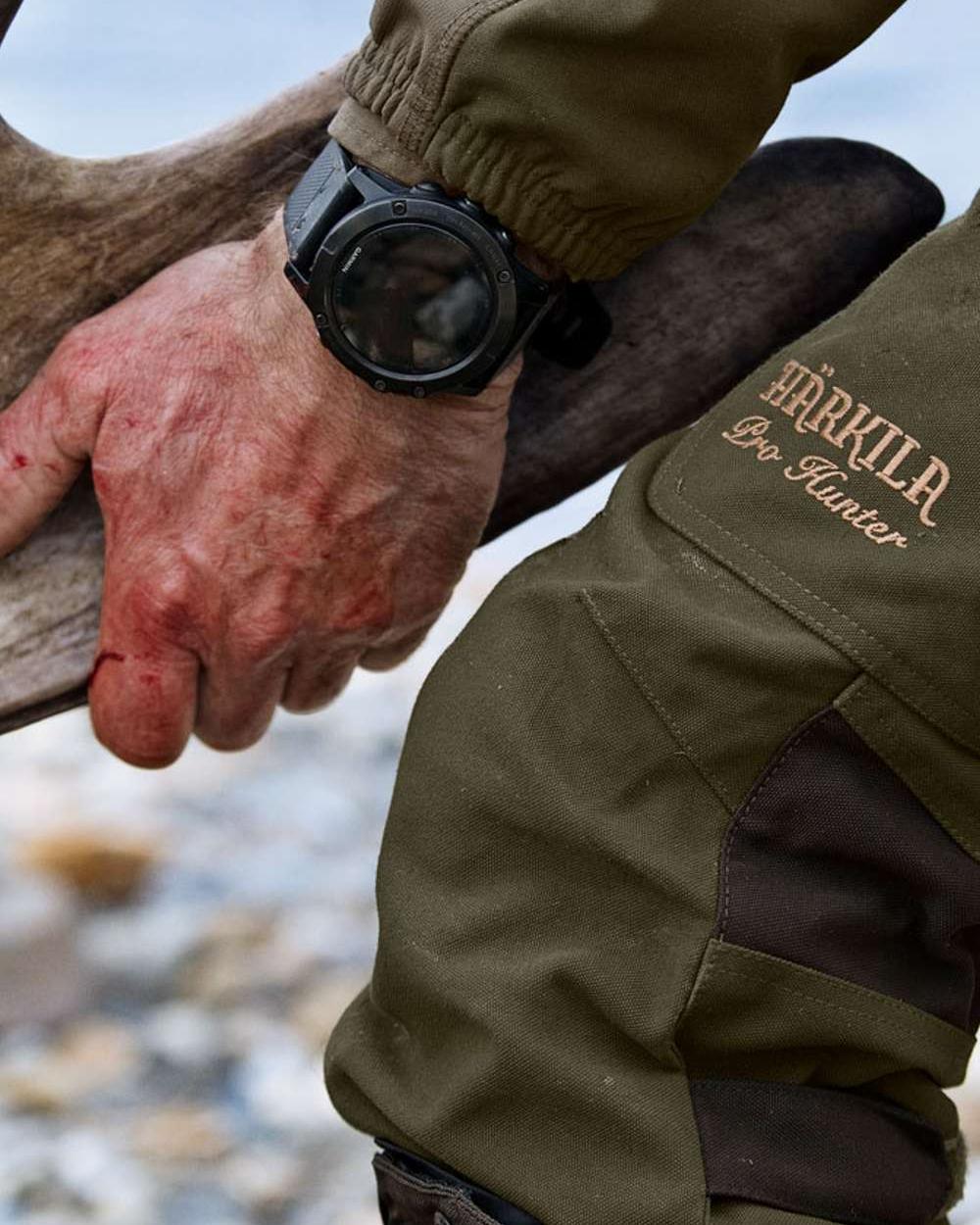 Willow Green Coloured Harkila Pro Hunter Endure Trousers on outdoor background #colour_willow-green