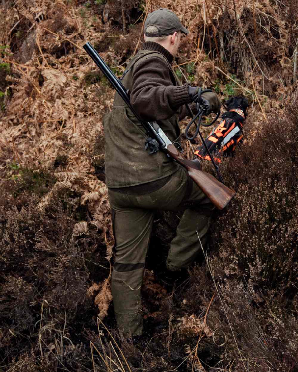 Willow Green Coloured Harkila Pro Hunter Leather Waistcoat on forest background #colour_willow-green