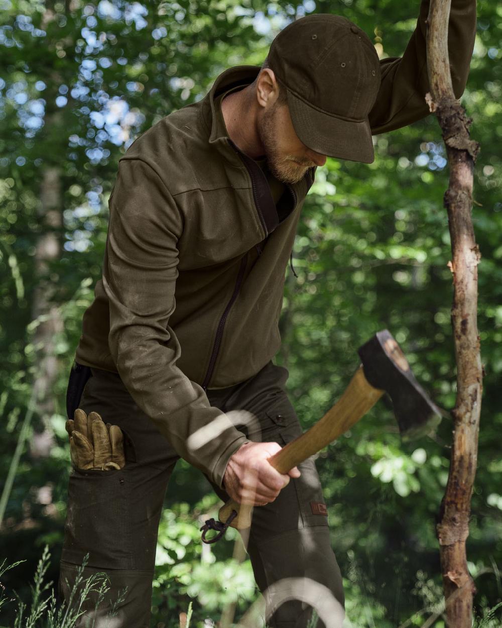 Light Willow Green Coloured Harkila Pro Hunter Light Trousers on forest background #colour_light-willow-green