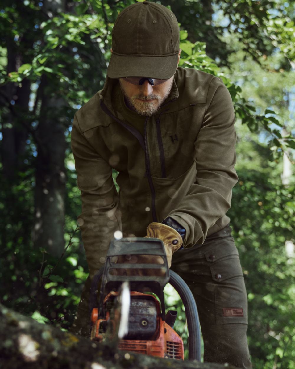 Light Willow Green Coloured Harkila Pro Hunter Light Trousers on forest background #colour_light-willow-green