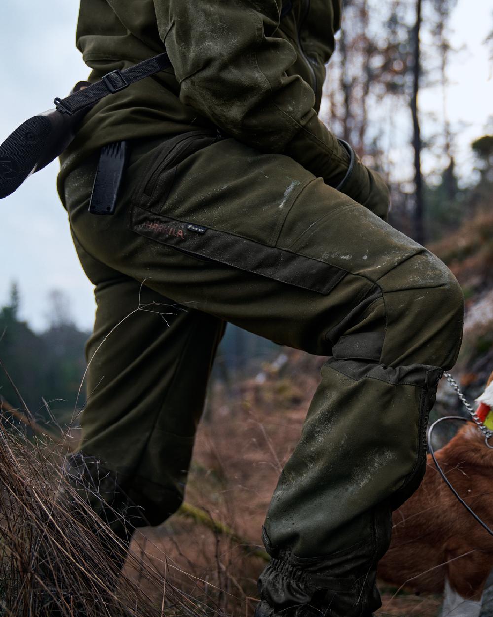 Willow Green Coloured Harkila Pro Hunter Move Trousers on outdoor background #colour_willow-green