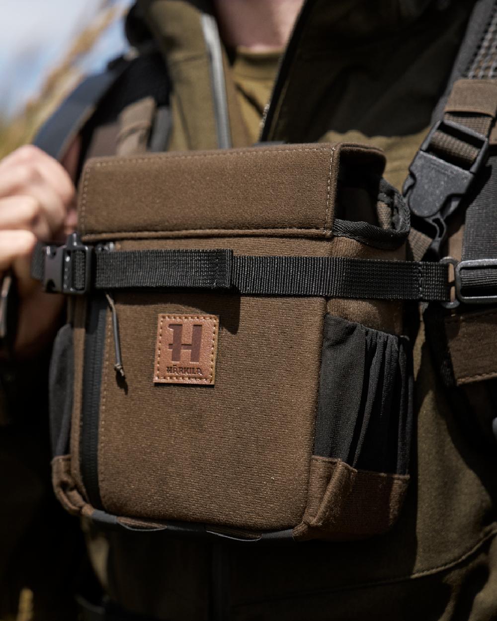 Willow Green Coloured Harkila Ragnar First Aid Backpack on blurry background #colour_willow-green