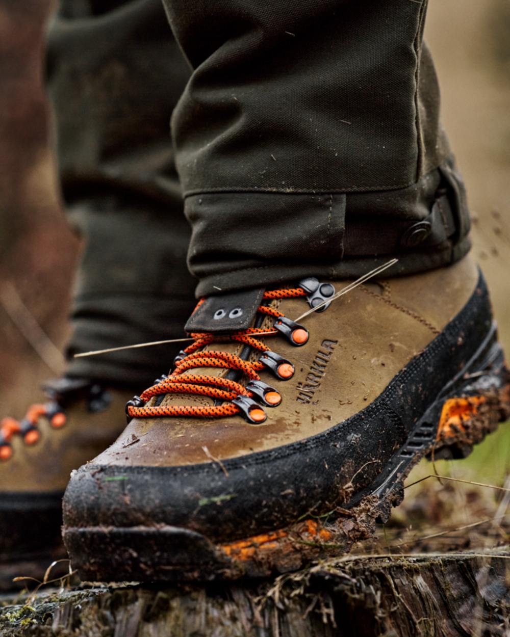 Mid Brown Orange Coloured Harkila Saxnas GTX Boots on mud background #colour_mid-brown-orange