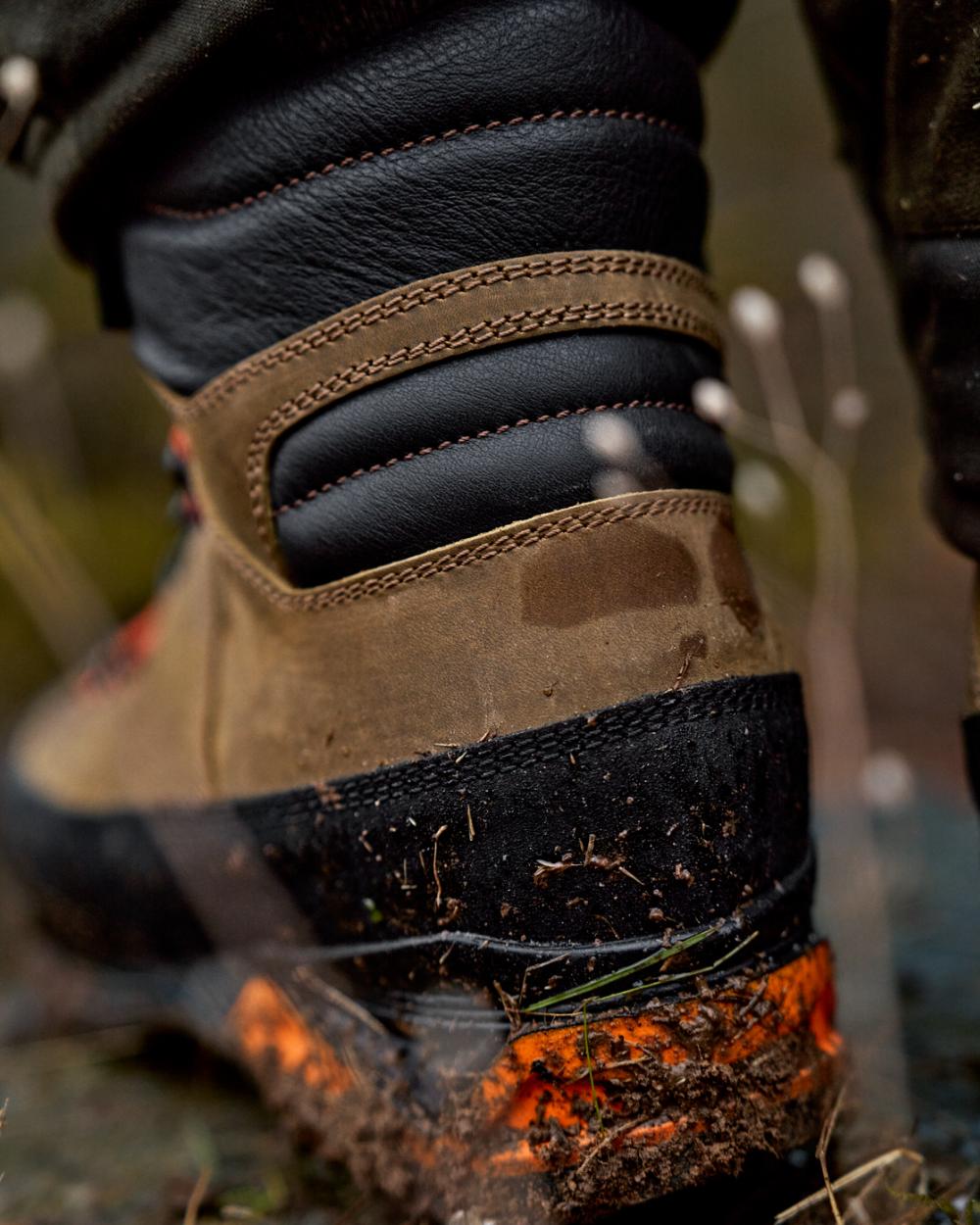 Mid Brown Orange Coloured Harkila Saxnas GTX Boots on mud background #colour_mid-brown-orange