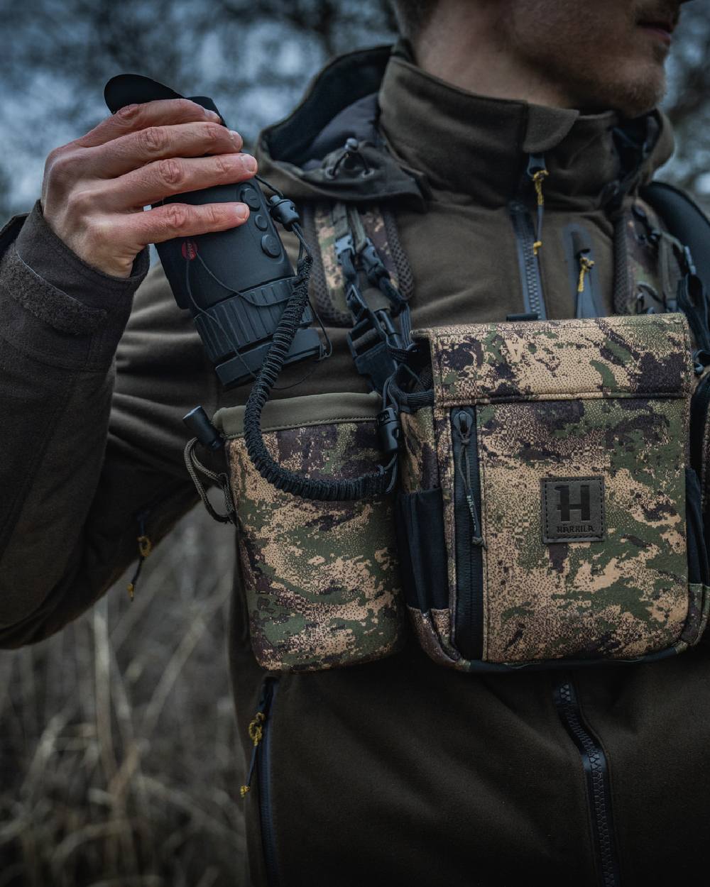 AXIS MSPForest Coloured Harkila Thermal Camo Spotter Pouch on blurry background #colour_axis-mspforest