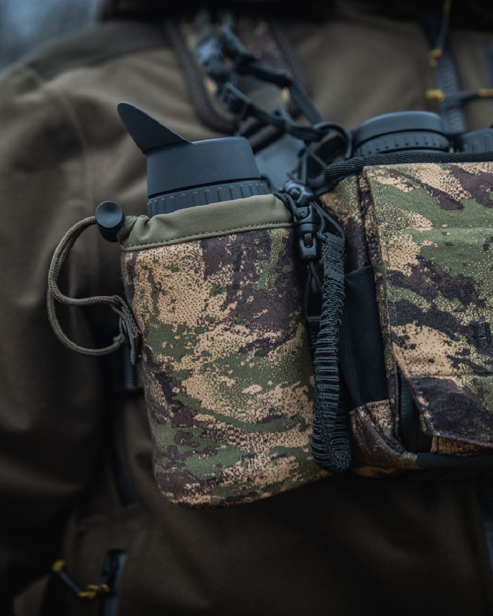 AXIS MSPForest Coloured Harkila Thermal Camo Spotter Pouch on blurry background #colour_axis-mspforest