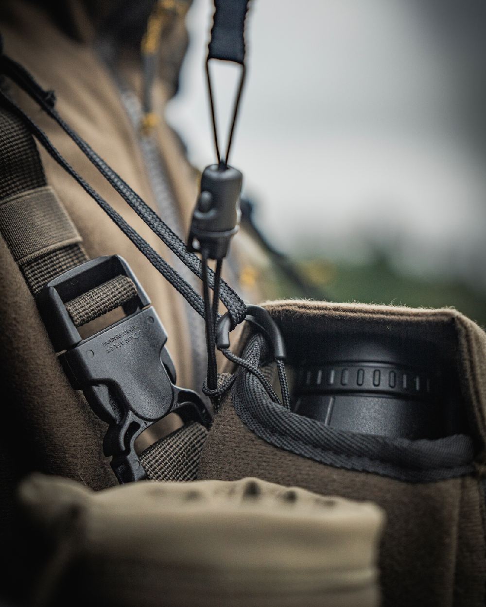 Dark Willow Green Coloured Harkila Thermal Spotter Pouch on blurry background #colour_dark-willow-green