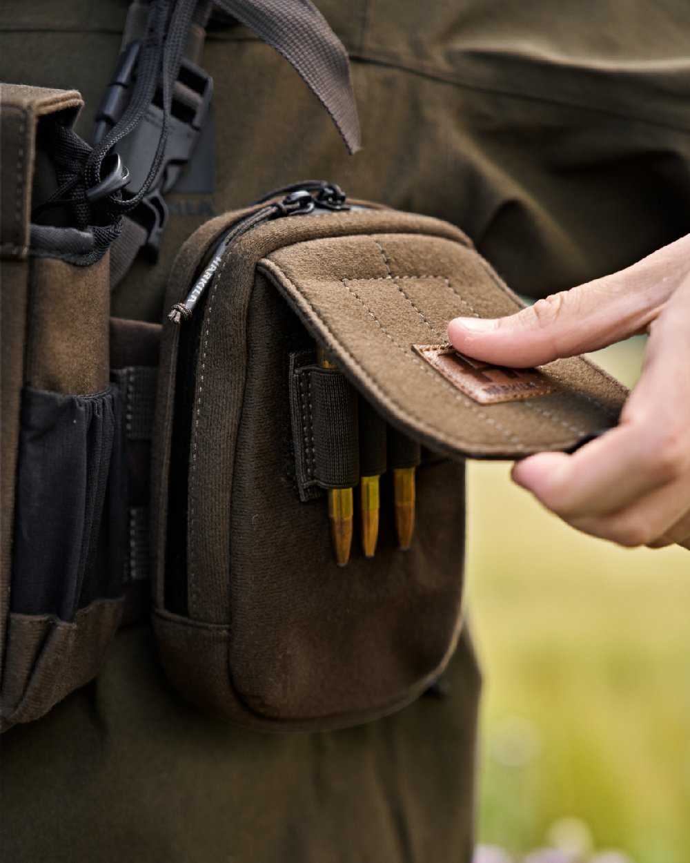Dark Willow Green Coloured Harkila Utility Pouch on blurry background #colour_dark-willow-green