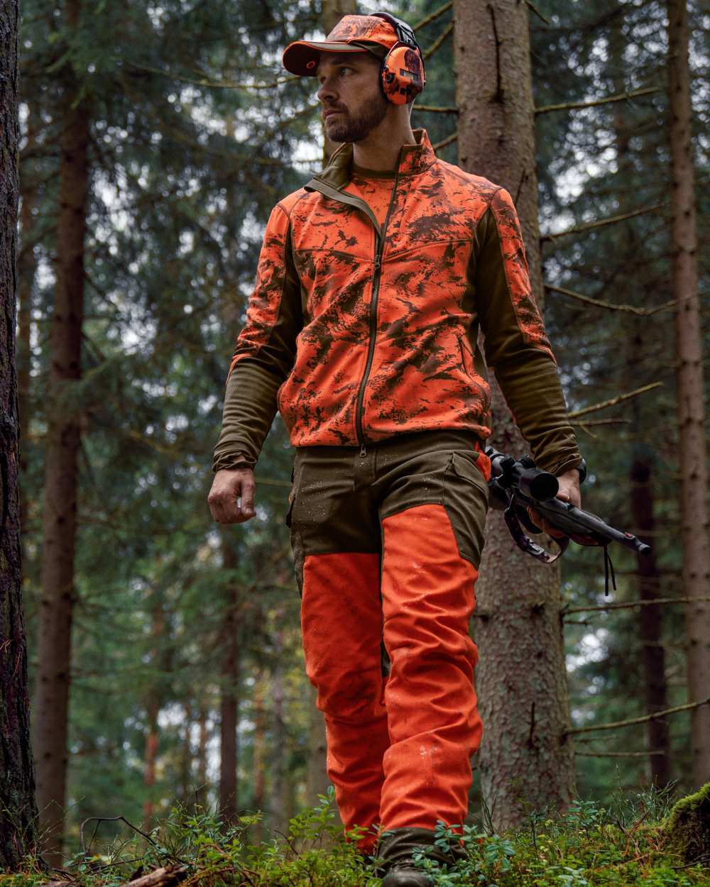 Wildboar Orange Coloured Harkila Wildboar Pro Camo Fleece Jacket on forest background #colour_wildboar-orange