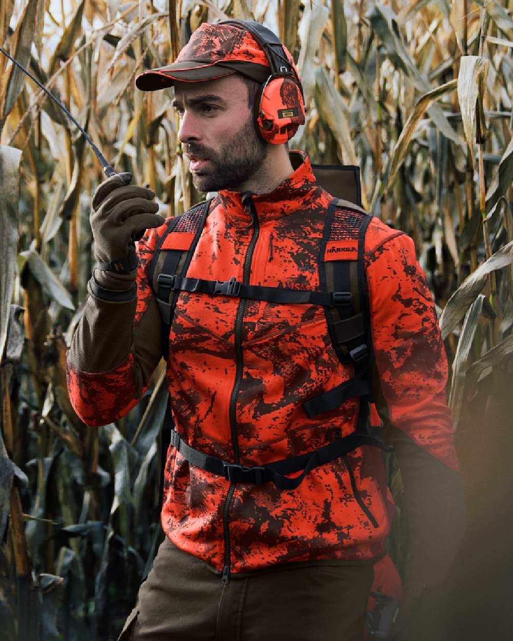 Wildboar Orange Coloured Harkila Wildboar Pro Camo Fleece Jacket on farm background #colour_wildboar-orange