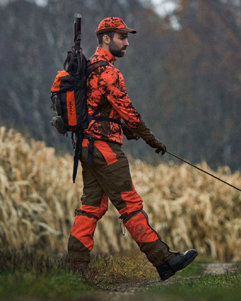 Wildboar Orange Coloured Harkila Wildboar Pro Camo Fleece Jacket on farm background #colour_wildboar-orange