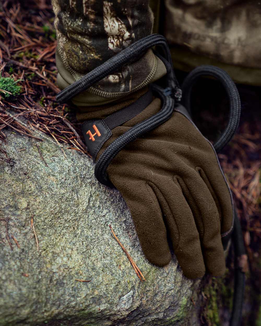 Willow Green Shadow Brown Coloured Harkila Wildboar Pro Gloves on outdoor background #colour_willow-green-shadow-brown