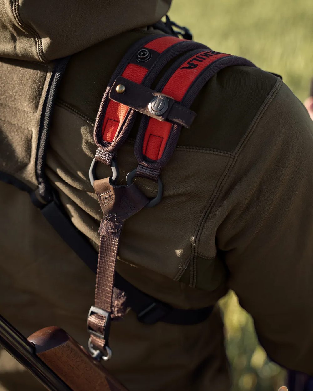 Orange Blaze Coloured Harkila Wildboar Pro Rifle Sling on blurry background #colour_orange-blaze