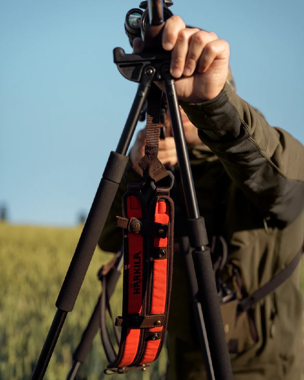 Orange Blaze Coloured Harkila Wildboar Pro Rifle Sling on blurry background #colour_orange-blaze
