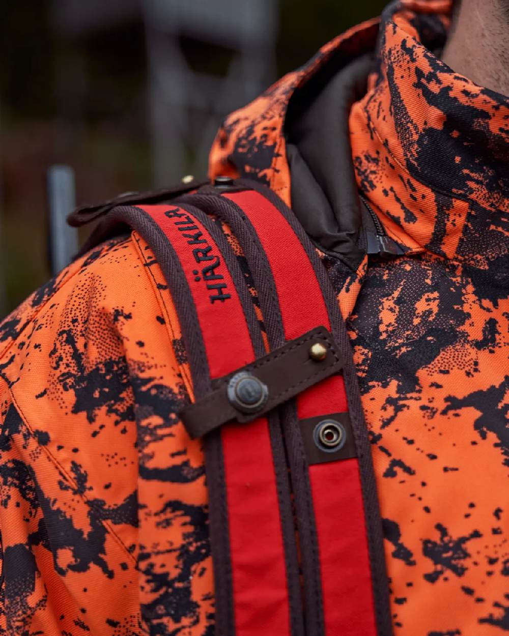 Orange Blaze Coloured Harkila Wildboar Pro Rifle Sling on blurry background #colour_orange-blaze