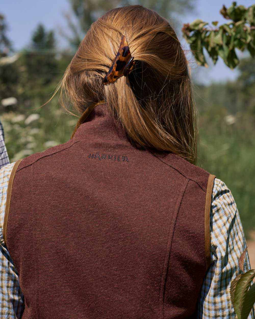 Dark Copper Coloured Harkila Womens Sandhem Pro Waistcoat on outdoor background #colour_dark-copper