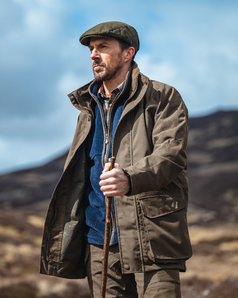 Green Coloured Hoggs of Fife Ballater Waterproof Field Jacket on blurry background #colour_green