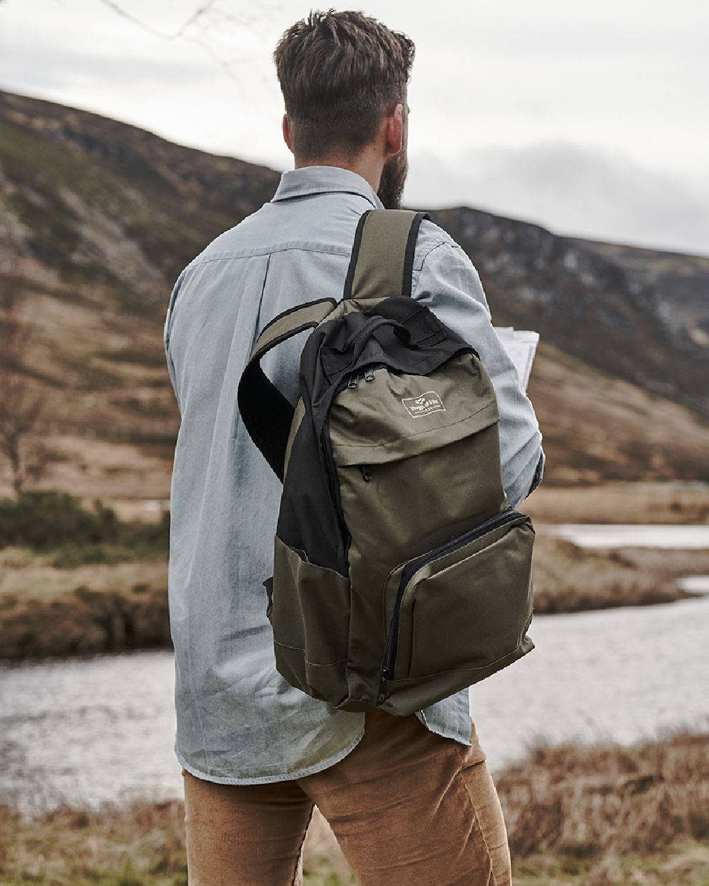 Green Black Coloured Hoggs of Fife Field & Trek Backpack on mountain background #colour_green-black