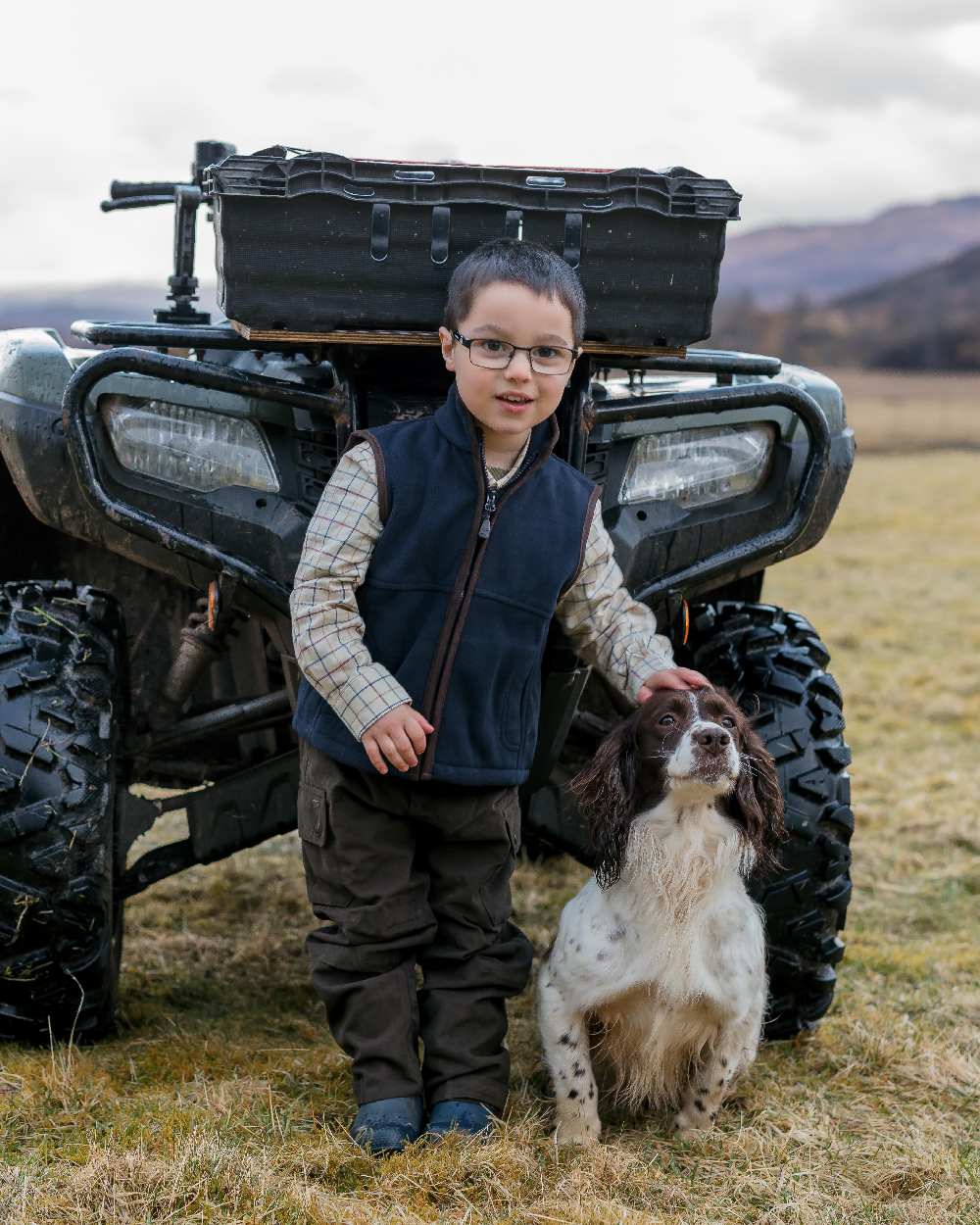 Dark Green Coloured Hoggs of Fife Junior Struther Waterproof Trousers on tractor background #colour_dark-green