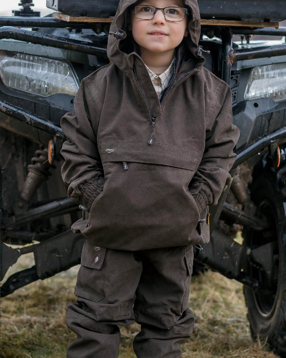Dark Green Coloured Hoggs of Fife Junior Struther Waterproof Trousers on tractor background #colour_dark-green