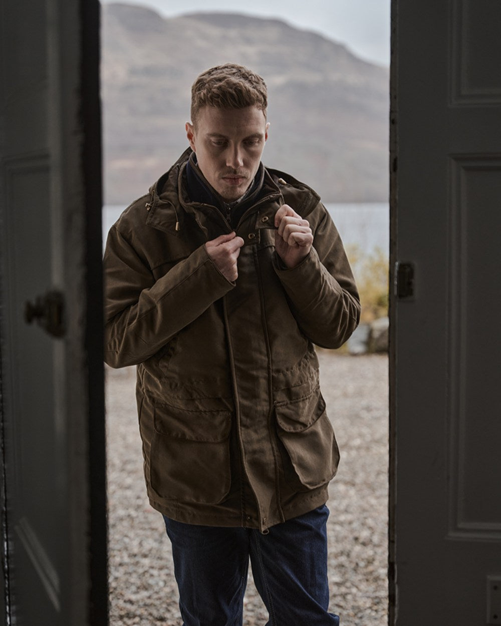 Olive Green Coloured Hoggs of Fife Kincraig Waterproof Field Jacket on mountain background #colour_olive-green
